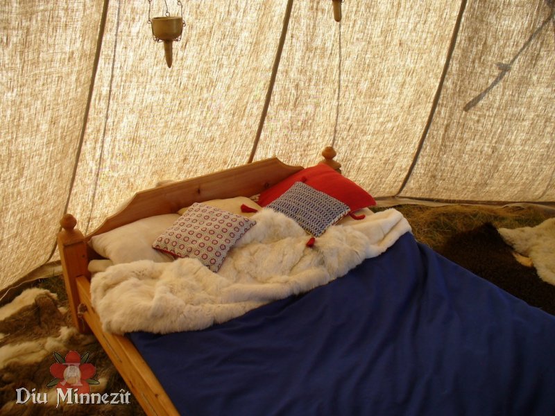Bett mit strohgefüllter Matraze, Unterbett aus Wolle und Leinen, wollgefüllten Kissen, Woll-und Pelzdecken.