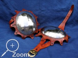 Kniebuckel aus getriebenen Stahl, auf Leder aufgenietet